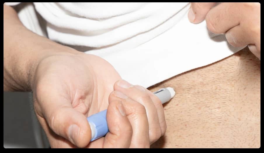 Person administering a weight loss injection with a pen device, illustrating the comparison between Mounjaro vs Ozempic for obesity treatment